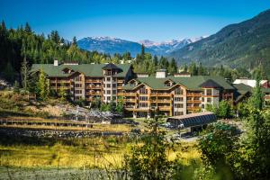 a large resort building with mountains in the background at First Tracks Lodge in Whistler