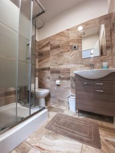 a bathroom with a tub and a sink and a toilet at Blue Lotus Apartments in Bratislava