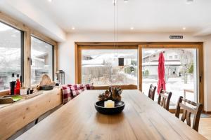 een eetkamer met een houten tafel en een groot raam bij Haus Tupferl in Niedernsill