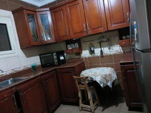 a kitchen with wooden cabinets and a table in it at بيراميدز رووف in Giza