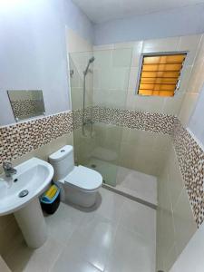 a white bathroom with a toilet and a sink at Fascinating Apt/Near the beach in Mendoza