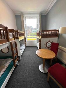 a room with bunk beds and a table and a window at Eden Quay Guesthouse Private Rooms in Dublin