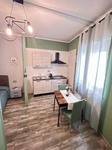 una cucina e una sala da pranzo con tavolo e sedie di Al Cantiere a San Giorgio Ionico