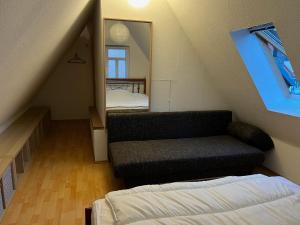 Cette chambre mansardée comprend un lit et un miroir. dans l'établissement Ferienwohnung Zwätzi, à Iéna