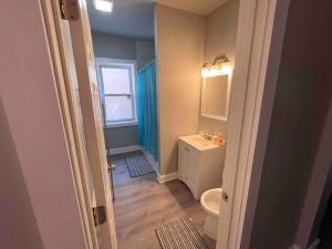 a bathroom with a sink and a toilet and a window at Cozy Luxury Apt~ near UChicago/HydePark/Lakeshore in Chicago
