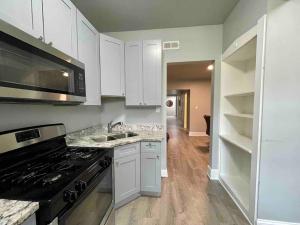 a kitchen with white cabinets and a stove top oven at Cozy Luxury Apt~ near UChicago/HydePark/Lakeshore in Chicago