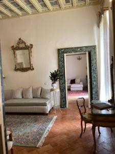 a living room with a couch and a mirror at Palazzo Lauri Spoleto in Spoleto