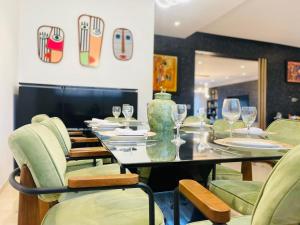 uma sala de jantar com uma mesa e cadeiras com copos de vinho em luxury Villa with pool next mall em Dar Bouazza