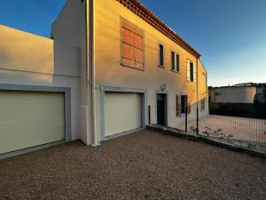 a house with two garage doors and a building at la porte medievale in Carcassonne