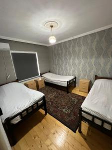 a room with two beds and a chalkboard on the wall at Qafqaz Family Home in Gabala