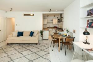 ein Wohnzimmer mit einem Sofa und einem Tisch in der Unterkunft Cosy apartment in the Heart of Nottinghill, 2mins to Portobello Road Market, Perfect for family or professionals in London