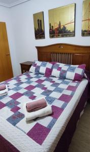 a quilt on a bed with two towels on it at CASA GARIJO - San Juan de los Terreros in San Juan de los Terreros