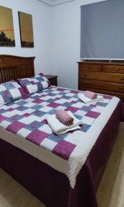 a bed with a blue and purple quilt with towels on it at CASA GARIJO - San Juan de los Terreros in San Juan de los Terreros +35 photos