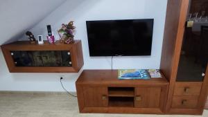 a living room with a television and a wooden entertainment center at CASA GARIJO - San Juan de los Terreros in San Juan de los Terreros