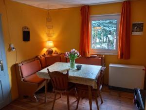 d'une salle à manger avec une table, des chaises et une fenêtre. dans l'établissement Hexen Haus, à Burghaslach