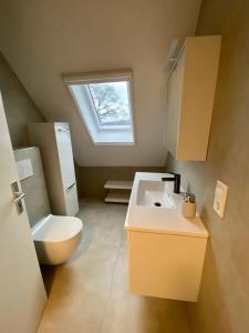 a bathroom with a toilet and a sink and a window at Pension zum Wohlfühlen Grotheer in Worpswede