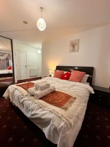 a bedroom with a large bed with red pillows at Luxury rooms in canary wharf in London