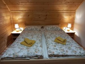 Ce lit se trouve dans une chambre en bois dotée de 2 tables de chevet. dans l'établissement Resort Dudukovic, à Slunj