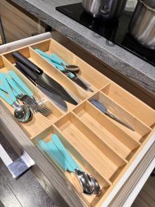 a drawer in a kitchen with utensils in it at Luxury rooms in canary wharf in London