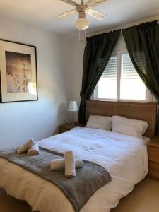 1 dormitorio con 1 cama blanca grande y ventana en Naranjos Condado, en Alhama de Murcia