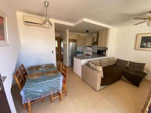 a kitchen and a living room with a table and a couch at Naranjos Condado in Alhama de Murcia
