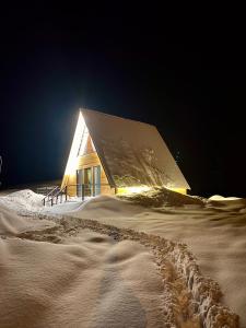 a building in the snow with a trail in the snow at Cottage in Gudauri Hillsideinn in Kʼumlistsʼikhe