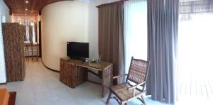 uma sala de estar com uma televisão e uma secretária com uma cadeira em Pousada Residencia Duna Paraiso em Maceió