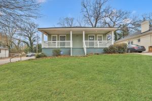 una casa verde con porche blanco y patio en GoodLiving: Serenity en Atlanta