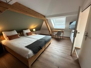 a bedroom with a large bed and a desk at Peterhof Sarnen in Sarnen