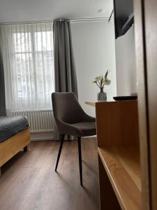 Zimmer mit einem Stuhl, einem Tisch und einem Fenster in der Unterkunft Peterhof Sarnen in Sarnen