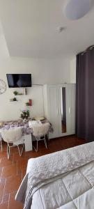 a bedroom with a bed and a table and a tv at Bed And Breakfast A CASA DI LEO in Tarquinia