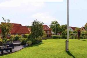 a park with benches and a pole in the grass at Carpenters Lodge in Mariager
