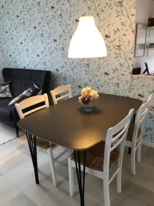 einen Esstisch mit Stühlen und einer Lampe in der Unterkunft Airy, cosy guesthouse in Mariager