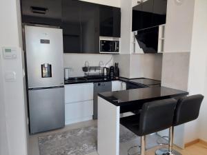 una cucina con frigorifero e piano di lavoro nero di The Stadium View Apartment a Sarajevo