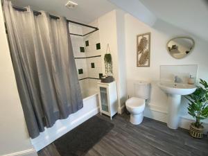 un baño con inodoro y lavabo en The Penthouse at Percy House Pet Friendly 2 Bedroom Apartment in Porthcawl Sleeps 4 people Located in the town centre, en Porthcawl 36 fotos más