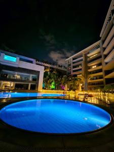 a large blue pool in front of a building at night at Sheraton Ocean 503 - Private Apartments in Cairo