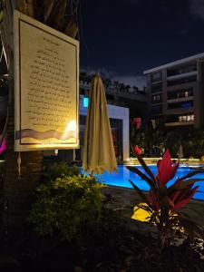 a umbrella and a sign next to a swimming pool at Sheraton Ocean 503 - Private Apartments in Cairo