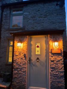 a house with a white door with lights on it at Homestead Cottage in Bradwell