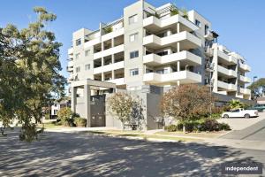 an apartment building with a car parked in front of it at Qbn Cracker: 2BR, 2BA, 2 secure b/ ment car parks in Queanbeyan