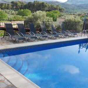 a group of chairs sitting next to a swimming pool at Casas Rurales Cerro Lobo in Yeste