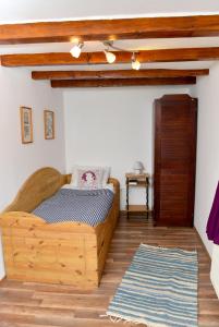 1 dormitorio con cama de madera y alfombra en Rigófütty Vendégház en Tiszaalpár