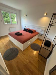 1 dormitorio con 1 cama con sábanas rojas y espejo en Beau studio plein centre ville en Beauvais