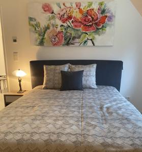 a bedroom with a bed with a painting on the wall at Pension zum Wohlfühlen Grotheer in Worpswede