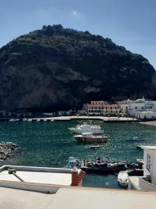 a group of boats in a body of water with a mountain at Casa Borgo Sant'Angelo in Ischia
