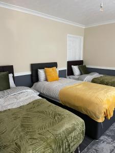 a room with two beds and a couch at Modern 4 Bed House for 9 guests in Tilbury