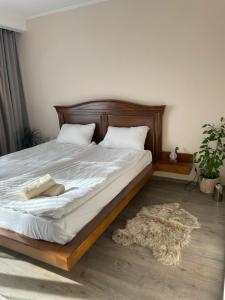 a bed in a bedroom with a rug on the floor at Tori apartament in Târgu-Mureş