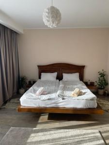 een slaapkamer met een groot bed met witte lakens bij Tori apartament in Târgu-Mureş