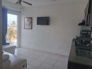 a white living room with a tv on the wall at Ph olas tower in Palo Grande
