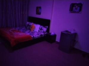 a purple bedroom with a bed in a room at My Home Stay Apartment in Abu Dhabi