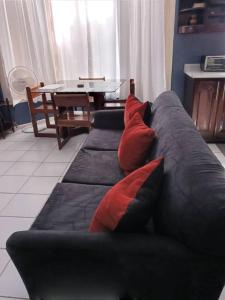 a black couch with red pillows in a living room at Refreshed Modern Country Feel Apartment in Ocho Rios